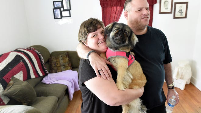 Angel Turner holds their dog, Lulu, as she stands with Michael Levy in the living room of the house they share in Staunton on Wednesday, July 1, 2015. Turner is legally blind while Levy is complete blindness.
