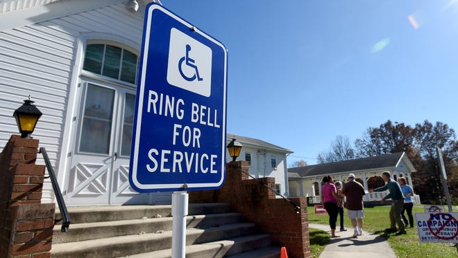A sign outside the Crimora voting precinct informs those with disabilities who are arriving to ring a bell for service on Tuesday, Nov. 3, 2015. 