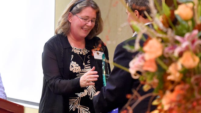 Jennifer Strother, executive director of Casa de Amistad, receives her Dawbarn Education Award during an award ceremony in Waynesboro on Wednesday, Nov. 4, 2015. Strother is one of ten people receiving the award this year.