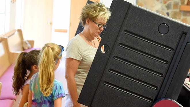 Becky Marcum casts her ballot with granddaughters Tegan Grimshaw, 6, and Reese Grimshaw, 8, behind her as she votes at the Ward 4 voting location in Staunton on Tuesday, June 14, 2016. 