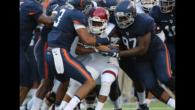 UTEP defenders stopped New Mexico State ballcarrier Xavier Hall Saturday. 