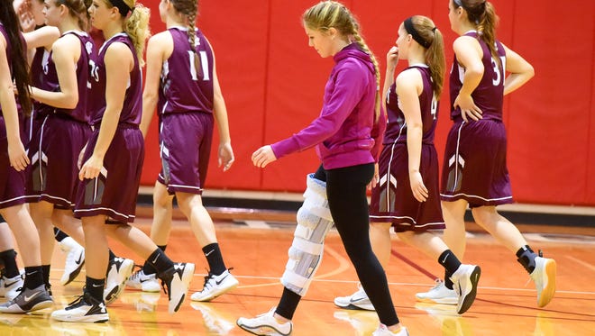 Stuarts Draft's Deborah Black walks back to the sidelines for the start of their Region 2A East girls game against East Rockingham played in Elkton on Thursday, Feb. 23, 2017. Although a leg injury may have benched her, she remains with her teammates through their playoff run.