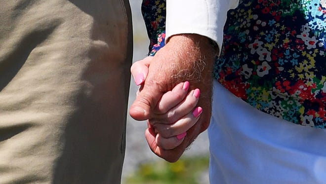 Patrick and Carol Webb hold hands as they walk together on Thursday, May 3, 2018. The husband and wife like to go walking at least 3 times each week. Carol was diagnosed with Alzheimer's disease in November 2016. 