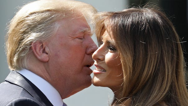 President Donald Trump kisses his wife,. first lady