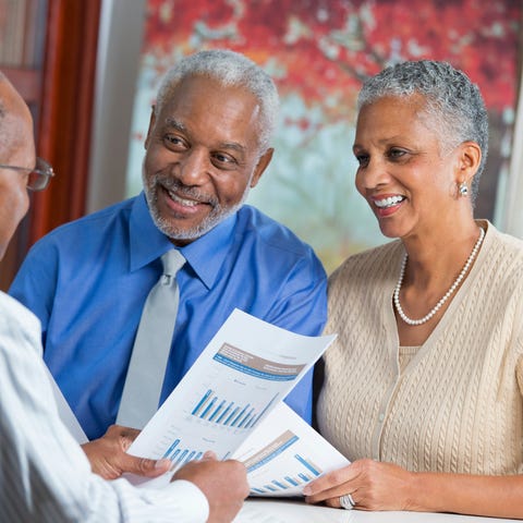 Older couple reviewing paperwork with financial ad