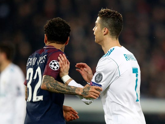 PSG's Dani Alves, left, holds Real Madrid's Cristiano Ronaldo during the round of 16, 2nd leg Champions League soccer match between Paris Saint-Germain and Real Madrid at the Parc des Princes Stadium in Paris, Tuesday, March 6, 2018. (AP Photo/Francois Mori)