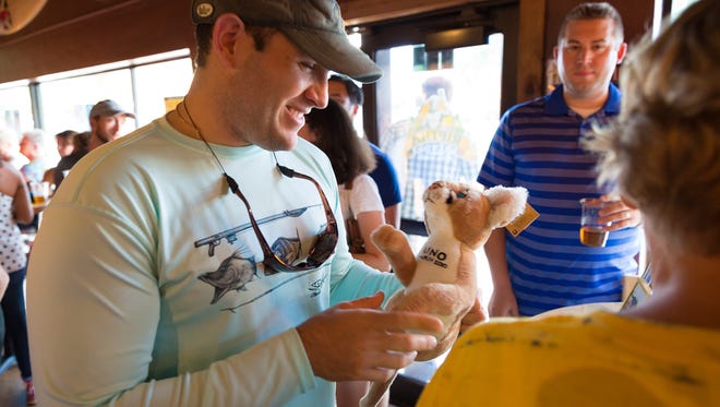 Naples resident Cliff Burmeister wins a stuffed animal version of Uno, the Naples Zoo's blind Florida panther, during the Brew for the Zoo event on Saturday, July 9, 2016, in Naples. The brewery unveiled its Uno Ale brewed in honor of a blind Florida panther at the Naples Zoo at Caribbean Gardens with proceeds from the event benefitting the zoo's panther conservation projects. (David Albers/Naples Daily News)