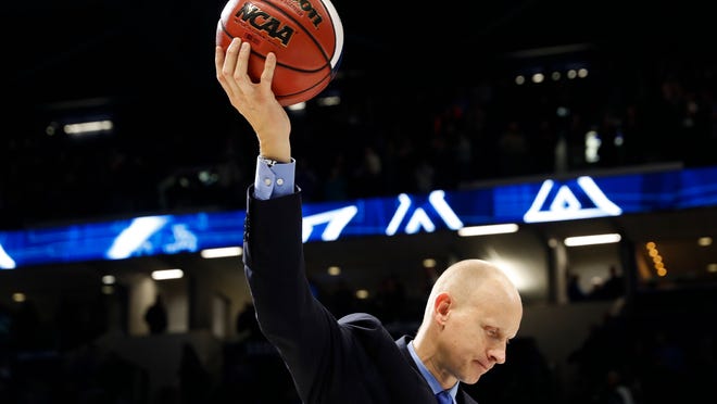 Xavier head coach Chris Mack holds a commemorative game ball after becoming the winningest coach in Xavier history after an NCAA college basketball game against St. John's, Wednesday, Jan. 17, 2018, in Cincinnati. Xavier won 88-82. (AP Photo/John Minchillo)