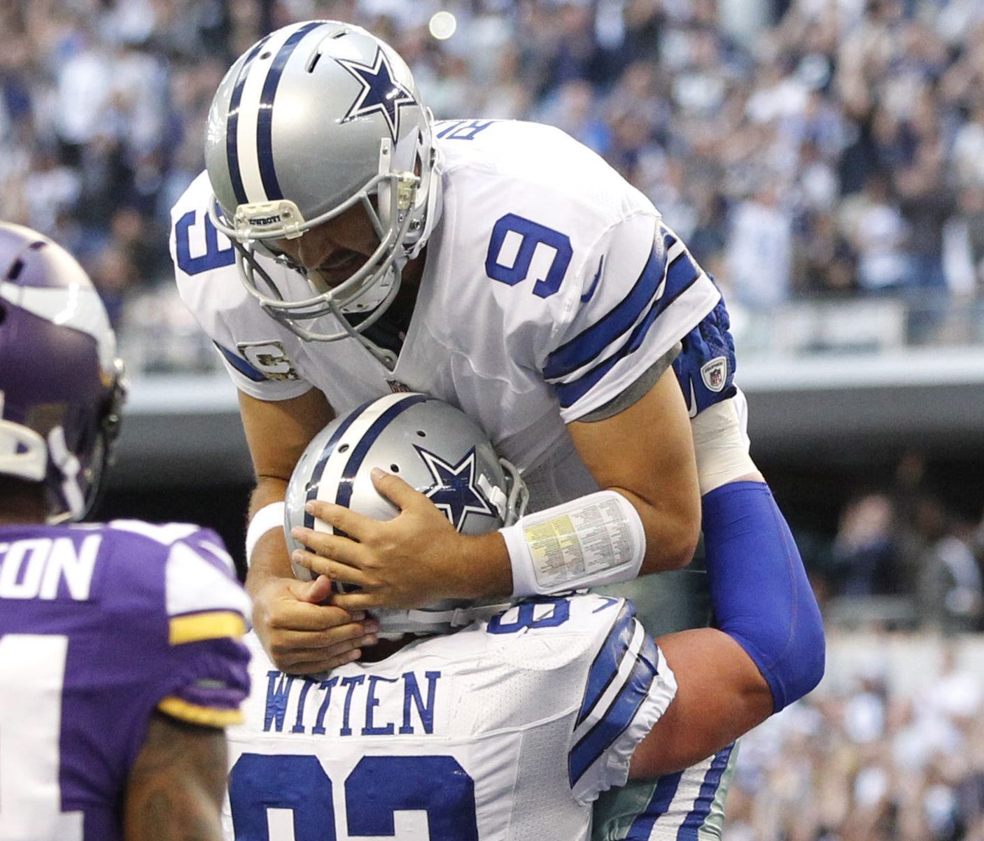 Former Dallas Cowboys quarterback Tony Romo (9) jumps in the arms of former tight end Jason Witten (82) during a game in 2013.
