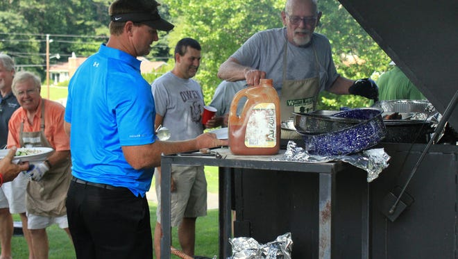 Super Bowl champion quarterback, and former Owen star, Brad Johnson grabs some barbecue near the clubhouse during the 2014 Warhorse Classic.
