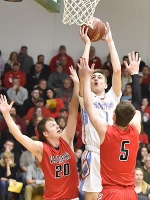 Southern Door's Ryan Claflin squeezes a shot under the basket between Valders' Treyner Sundsmo, left, and Kyle Tuma during a WIAA Division 3 sectional semifinal game Thursday at Ashwaubenon.