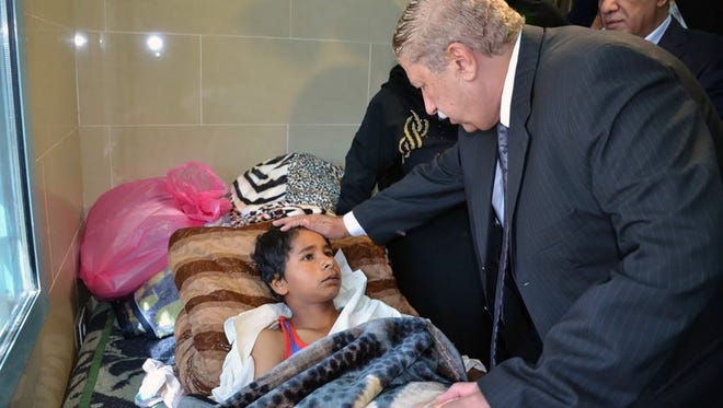 Yassin Taher (right) the Ismailia governor, visits victims of the attack that targeted the al-Rawdah mosque near North Sinai's provincial capital of El-Arish, on Nov. 25, 2017.