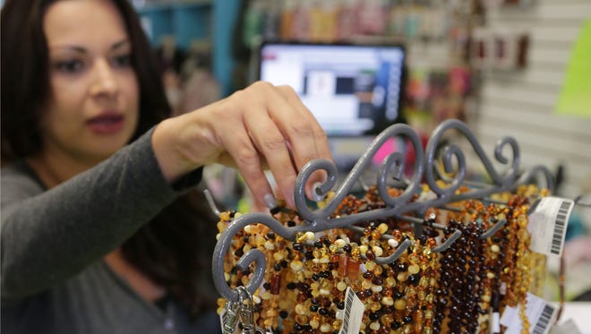 Yanette Diaz adjusts a display of amber teething necklaces made for infants and sold at Zoolikins, a shop geared for pregnant mothers and children up to 5 years old in downtown Chandler.