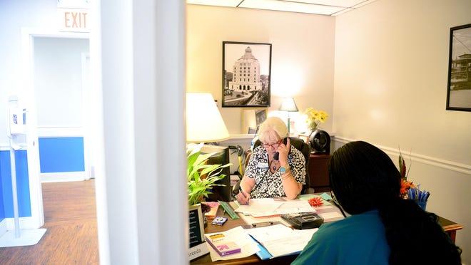 Brenda Wheeler talks on the phone with Duke Energy about Kwana Bailey's energy bill at Eblen Charities last October.