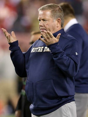 FILE - In this Oct. 31, 2015, file photo, Notre Dame head coach Brian Kelly gestures to his players as they warm up before an NCAA college football game against Temple, in Philadelphia. Notre Dame (2-3) visits the Wolfpack (3-1) on Saturday in a game that could be affected by the threat of severe weather from Hurricane Matthew. “We’ll deal with the elements,” coach Brian Kelly said, “just like North Carolina State will.”(AP Photo/Mel Evans, File)
