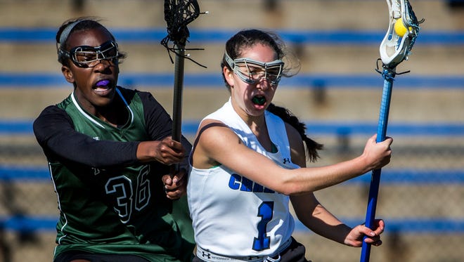 Charter of Wilmington's Michelle Shulkov (1) works around Tower Hill's Jade Olurin during the Force's 10-9 win on March 29. Charter moved into this week's girls lacrosse rankings at No. 3.