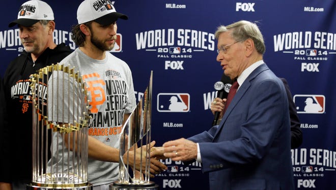 MLB commissioner Bud Selig presents San Francisco Giants pitcher Madison Bumgarner with the MVP trophy next to the Commissioner's Trophy after Game 7.