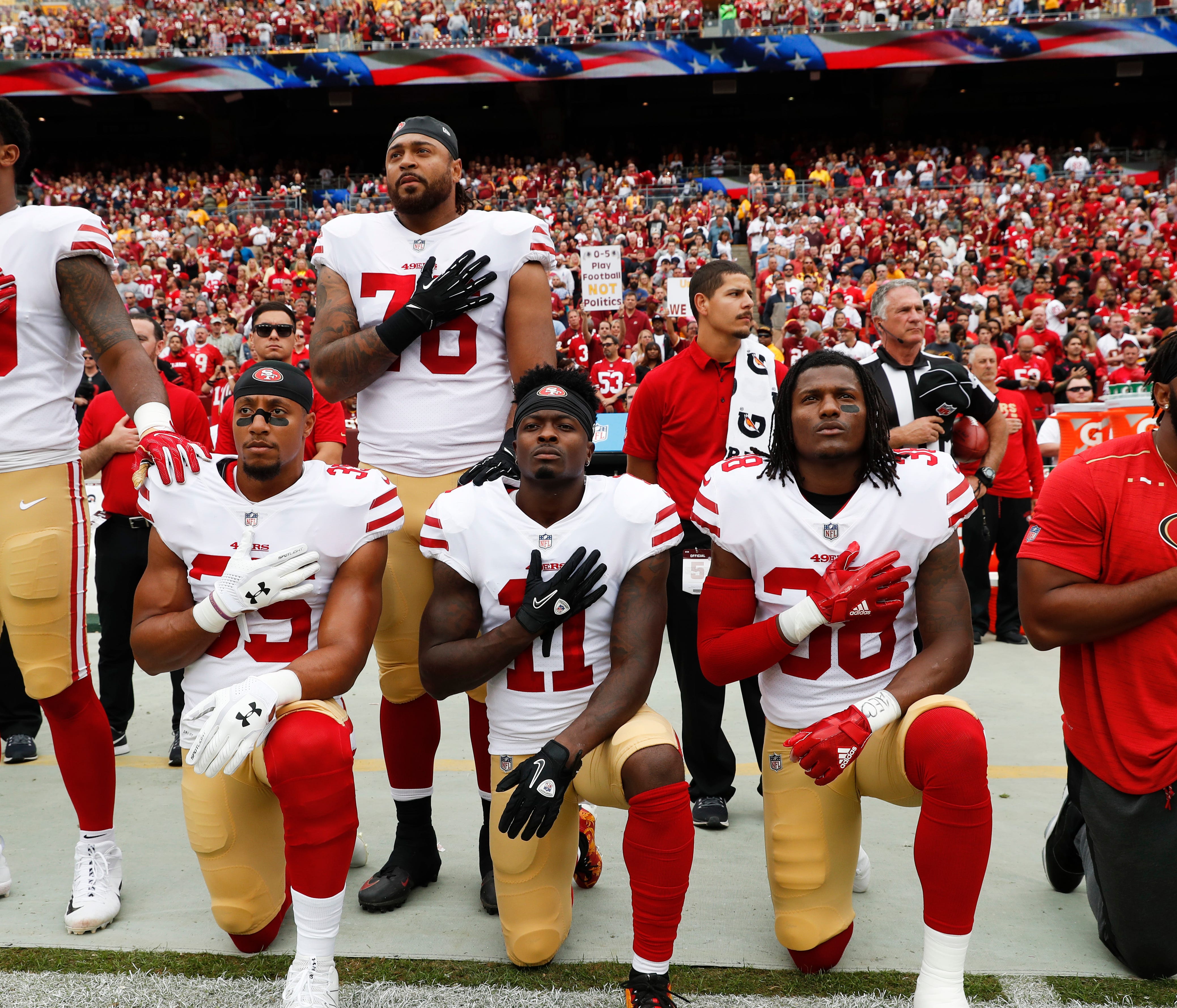 Member of the San Francisco 49ers kneel and stand during the playing of the National Anthem before an NFL football game against the Washington Redskins in Landover, Md., Sunday, Oct. 15, 2017. Kneeling are (L-R) strong safety Eric Reid (35), wide rec