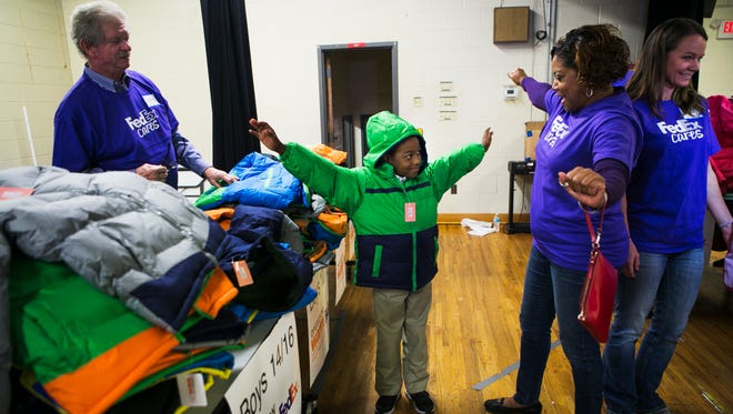 Third grade student Demazio Johnson, 8, raises his arms to show the fit of his new coat to Cathey Cooper, a FedEx employee, during a coat drive at Newberry Elementary School on Thursday. FedEx Cares partnered with Operation Warm to provide more than 450 students at Newberry with a "gift of warm." The donation was made possible through a FedEx team member as well as a grant from FedEx Cares. FedEx Cares is the company's global giving platform through which FedEx will invest $200 million in more that 200 global communities by 2020 to create opportunities and deliver positive change around the world. Operation Warm's mission is to build self-esteem through pride and ownership while increasing school attendance and overall wellness within a child. "We're so excited about this," said Rae Lyn Rushing, senior communications specialist, FedEx Global Media. "Just seeing the looks on the child's faces -- that says it all. Just seeing their joy and excitement ... seeing their eyes light up -- that's what FedEx Cares is all about. Just making the world a better place; making our communities a better place."