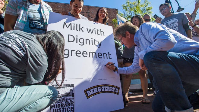 Ben & Jerry's CEO Jostein Solheim, right, signs a facsimile contract during a news conference where the ice cream maker and Migrant Justice announced an agreement in Burlington on Tuesday, October 3, 2017. The Milk with Dignity program seeks to ensure that milk provided to Ben & Jerry's is produced under fair working conditions.