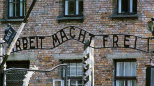 A view of the gates leading into the Auschwitz concentration camp. The sign reads "Work Sets You Free"