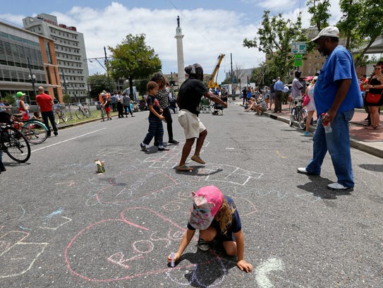 Roscoe Adair, 6, draws a heart with chalk in the street