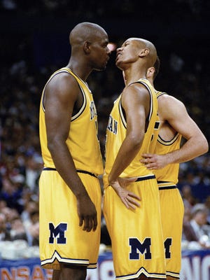 Michigan's Chris Webber, left, and Jalen Rose talk during their NCAA championship game with North Carolina at the Superdome in New Orleans on April 6, 1993.