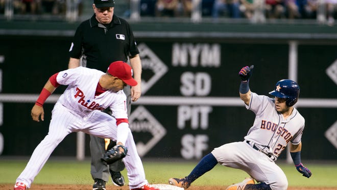 Houston Astros' Jose Altuve, right, slides into second base for a double as Philadelphia Phillies second baseman Cesar Hernandez, left, looks to apply the tag during the third inning Monday.