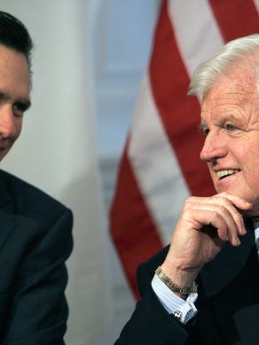 Mitt Romney, left, talks with then-senator Edward Kennedy, D-Mass., during a bill-signing ceremony and joint news conference at the Statehouse in Boston, on Feb. 4, 2005.