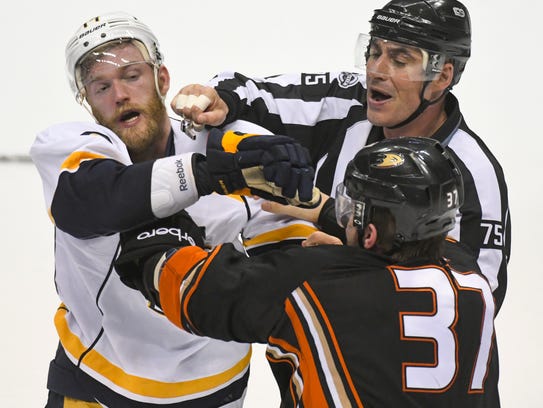 A referee tries to break up a fight between Nashville