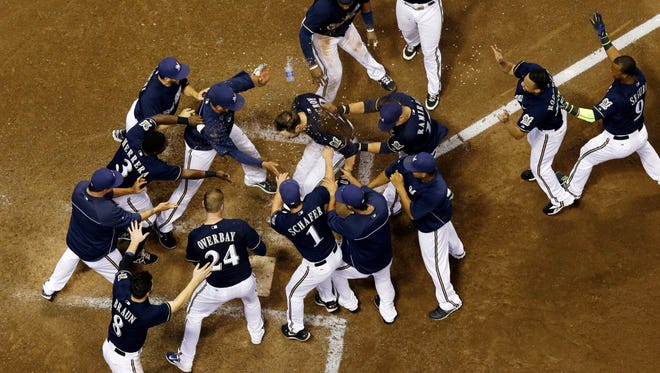 Brewers catcher Jonathan Lucroy celebrates with teammates after hitting a walk off home run Tuesday night against the Reds.