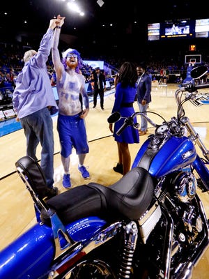 MTSU fan Nate Moorehead gets the keys to his new Harley Davidson motorcycle from Tim Keach after winning the bike during a shooting contest during the half-time of the Western Kentucky game on Thursday, March. 1, 2018, at MTSU.