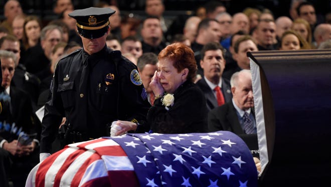 Esther Marie Connell, the mother of fallen Metro police Officer Eric Mumaw, is assisted by an officer in front of her son's casket during the memorial service at Cornerstone Church in Madison on Monday, Feb. 6, 2017. Mumaw died Thursday in the line of duty.