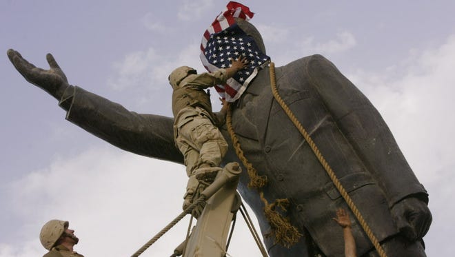 Toppling a statue of Saddam Hussein in April 2003.