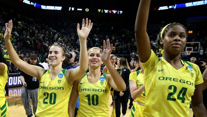 Oregon's Sabrina Ionescu, left, Lexi Bando and Ruthy Hebard, right, wave to their fans after defeating Minnesota 101-73 in the second-round game in the NCAA women's college basketball tournament in Eugene, Ore., Sunday, March 18, 2018. (AP Photo/Chris Pietsch)