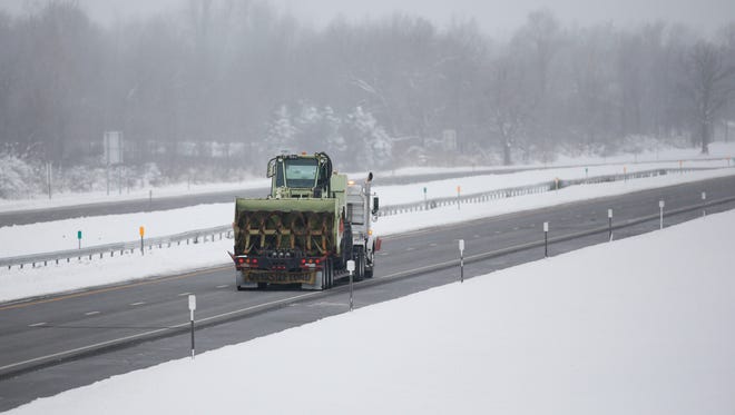 A truck carries a snow-clearing vehicle along the New York State Thruway headed for the Buffalo earlier this week. A large portion of the Thruway had been shut down since Tuesday.