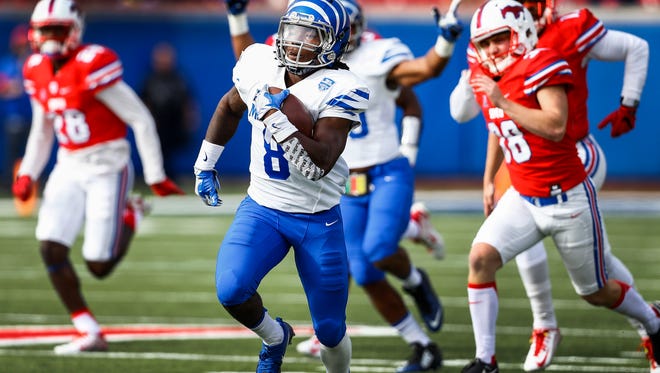 University of Memphis kick returner Darrell Henderson (middle) runs past the SMU defense for a 99-yard kickoff touchdown at Gerald J. Ford Stadium in Dallas Saturday.