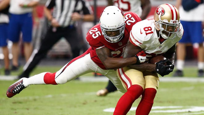 Arizona Cardinals Jerraud Powers tackles San Francisco 49ers Anquan Boldin in the first half on Sept. 27, 2015, in Glendale.