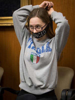 MSU student Rachel Jansen puts on a symbolic gag reading "SILENCED" to make her voice heard, Friday, Dec. 15, 2017, prior to the first MSU Board of Trustees meeting since the sentencing of former MSU sports medicine doctor Larry Nassar.