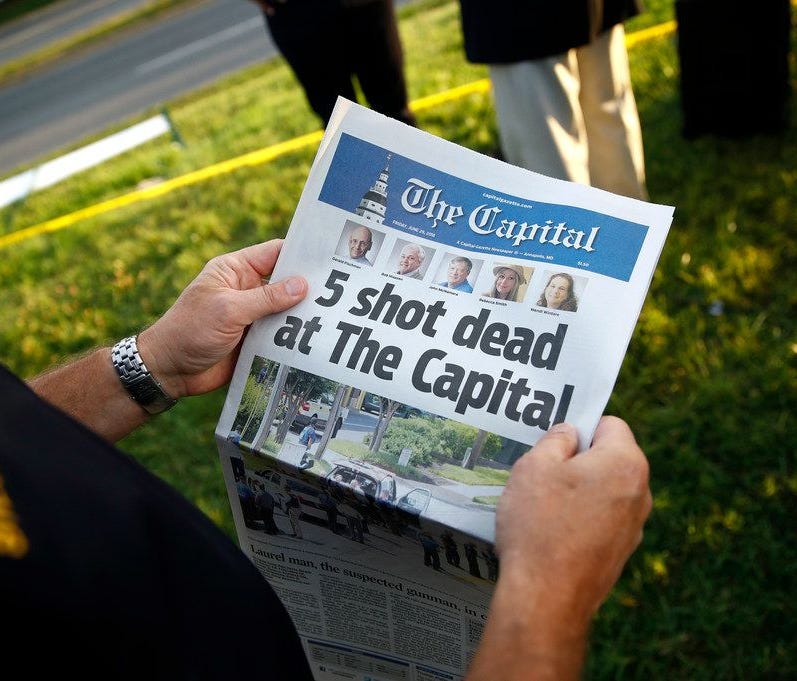 County executive of Anne Arundel County holds copy of The Capital Gazette