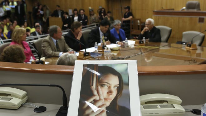 FILE - In this March 25, 2015, file photo, a portrait of Brittany Maynard sits on the dias of the Senate Health Committee at the Capitol in Sacramento, Calif., as lawmakers took testimony on proposed legislation allowing doctors to prescribe life ending medication to terminally ill patients. A San Diego Superior Court judge is expected Friday, July 24, 2015, to hear a motion to dismiss a lawsuit against the state a single mom given only months to live and other California right-to-die advocates. Aid-in-dying advocates thought the nationally publicized case of Maynard, the 29-year-old California woman with brain cancer who moved to Oregon to legally end her life last fall, might usher in a wave of state laws allowing doctors to prescribe life-ending medications. (AP Photo/Rich Pedroncelli)