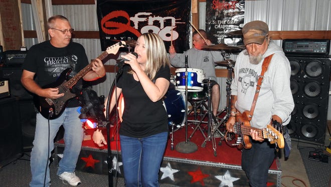 Gayle Gardner sings while Rick Bennett, left, plays guitar, Joe Bowman plays bass and Adam Spangler plays drums. Gayle Force Wind is a local modern rock band.