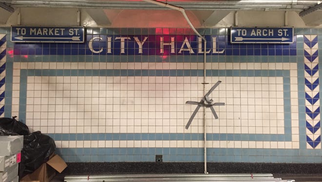 Tiles indicate City Hall Station in Camden, while directional signs point to Market and Arch streets, respectively.