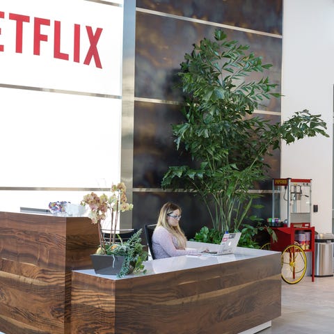 Person sitting at a reception desk. The Netflix lo