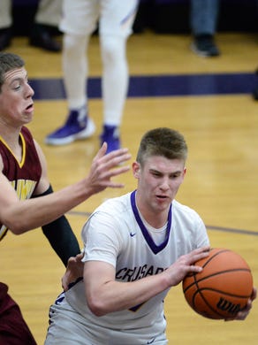 Lancaster Catholic’s Chad Wenger turns to make a pass with Columbia’s Jarod Kashner in his face.