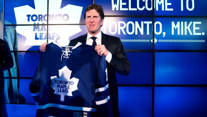 Toronto Maple Leafs coach Mike Babcock poses with a team jersey May 21, 2015.