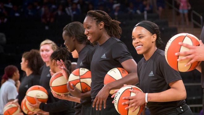 In this Wednesday, July 13, 2016 file photo, members of the New York Liberty basketball team await the start of a game against the Atlanta Dream, in New York. The WNBA has fined the New York Liberty, Phoenix Mercury and Indiana Fever and their players for wearing plain black warm-up shirts in the wake of recent shootings by and against police officers. All three teams were fined $5,000 and each player was fined $500.
