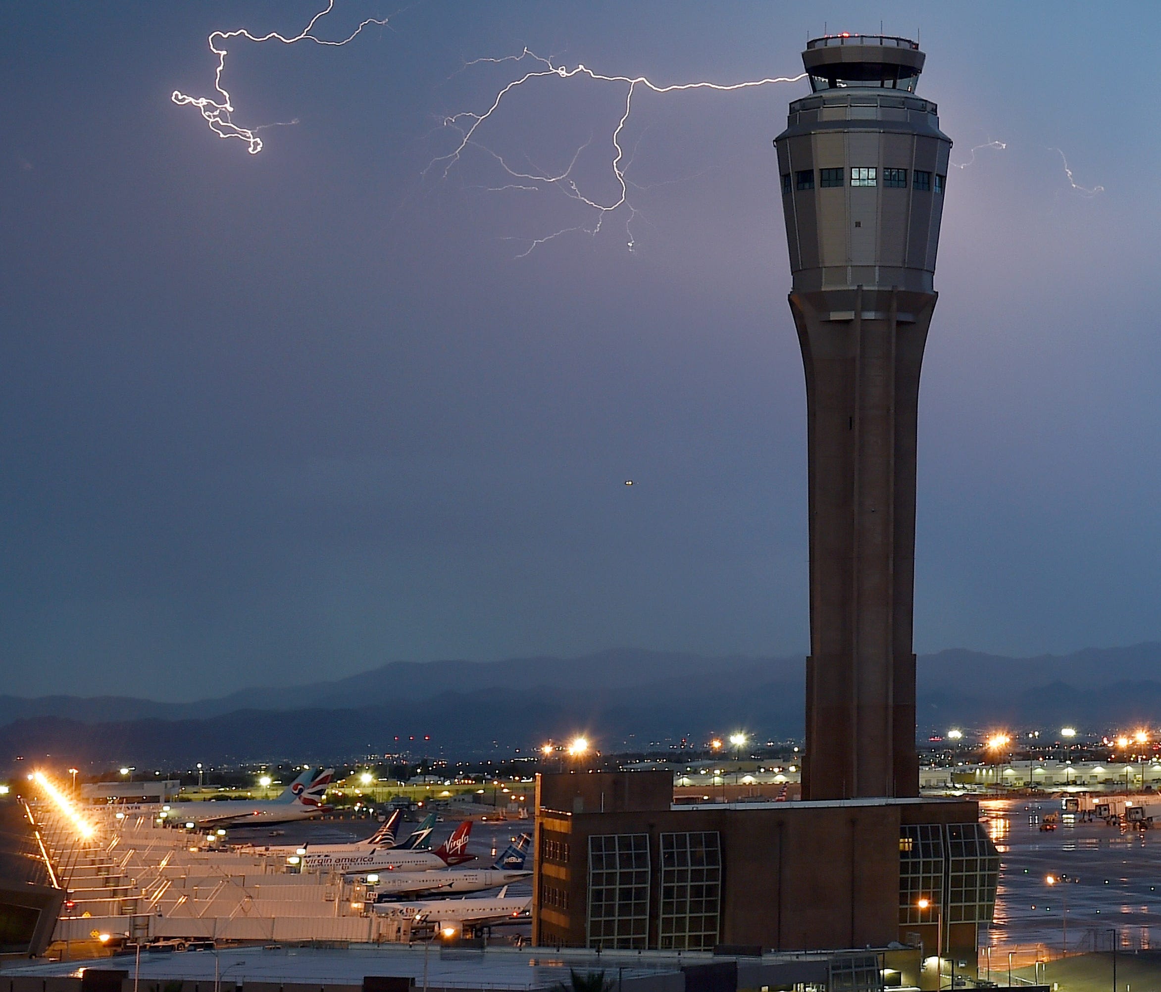 Lightning flashes behind a control tower at Las Vegas McCarran International Airport during a thunderstorm on July 6, 2015.