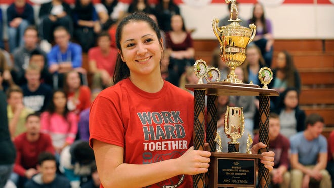 Gia Milana holds her Miss Volleyball trophy during a pep rally Monday at Romeo High.