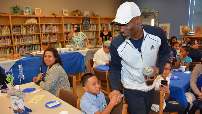 Rocket Ismail moves like a wide receiver negotiating tables full of parents and students in Arcelia Guillermo-Rios fifth grade dual-language classroom as he shakes hands with every student during a reception held in the school library reception held in his honor.